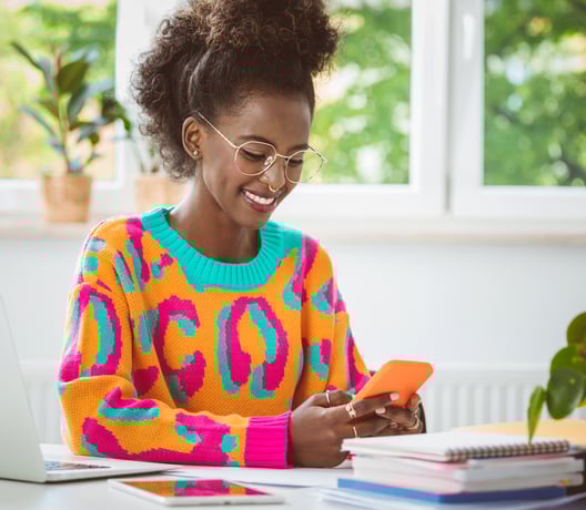 Young woman in colorful sweater on phone